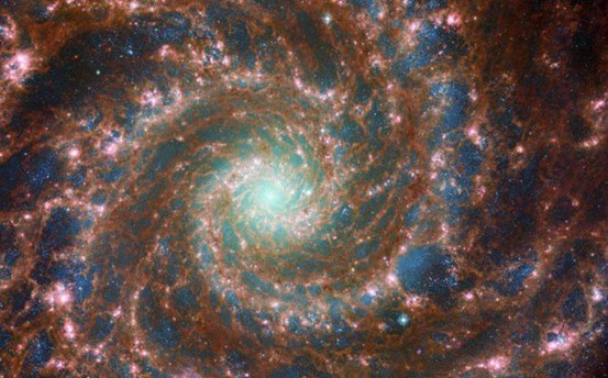 صورة مركبة للمجرة الشبح تجمع بين مُشاهدات تلسكوب هابل وتلسكوب ويب. (بجهود ESA/Webb, NASA & CSA, J. Lee and the PHANGS-JWST Team; ESA/Hubble & NASA, R. Chandar)